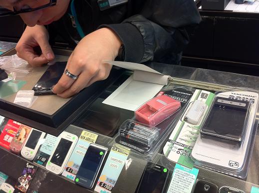 Broadway staff puts up a screen protector on Galaxy S